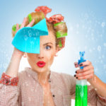 Funny housewife with rag / wipe and cleaning spray for window. Foam / soap on glass